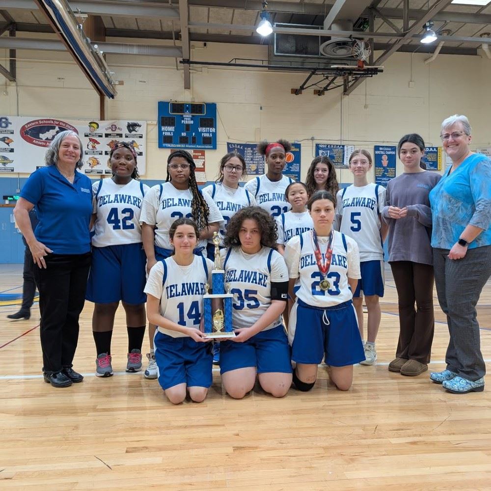  Photo of DSD girls' basketball team with coaches in school gym.